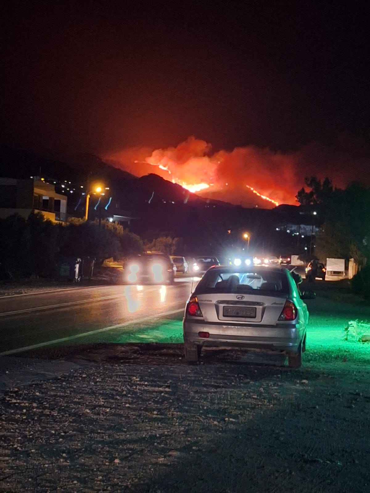 Die Flammen nähern sich Koutsounari. Die Berge im Hintergrund sind durch das Feuer hell erleuchtet.